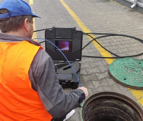 zdjęcie hydraulika używającego kamery inspekcyjnej do diagnostyki rur