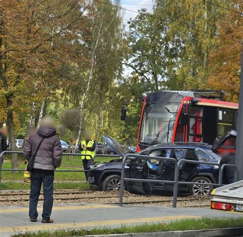 Zniszczona wywrotka leżąca na samochodzie osobowym na skrzyżowaniu, służby ratunkowe