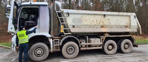 Ciężarówka wywrotka na wadze, obok inspektorzy ITD