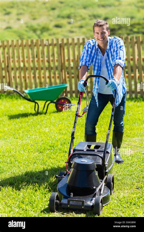 Thematic photo of a person mowing a lawn with an electric lawnmower in a home garden