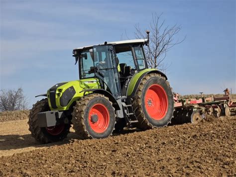traktor z podpiętą broną aktywną na polu
