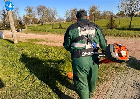 Fotografia nowoczesnego ciągnika komunalnego w akcji, wykonującego prace porządkowe w mieście