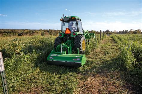 Thematic photo of a flail mower working in a field with tall grass and brush