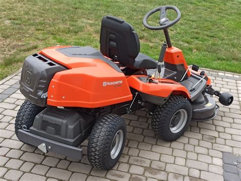 Traktorek kosiarka Husqvarna na tle ogrodu