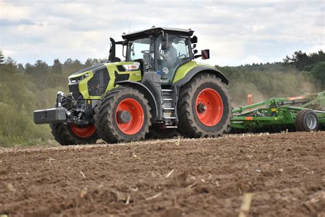 Zdjęcie ciągnika Claas Axion 9 CMATIC podczas pracy z ciężkim sprzętem
