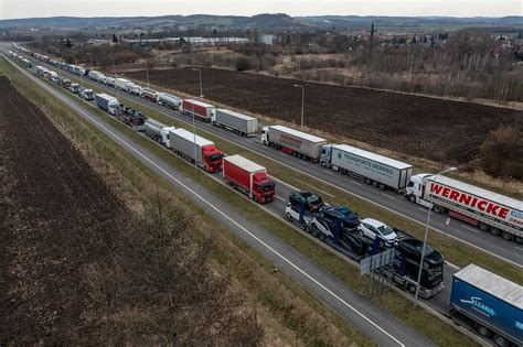 Zdjęcie przedstawiające grupę ciężarówek różnych marek na drodze