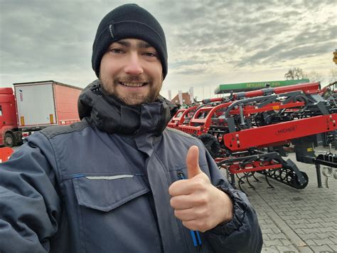 Wnętrze nowoczesnej hali serwisowej Agropol Zakrzewo z mechanikami i maszynami