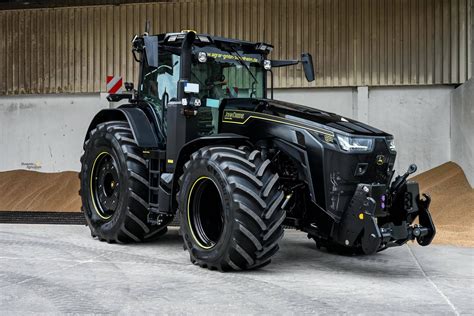 zdjęcie czarnego ciągnika John Deere 8R 340 pracującego z pługiem