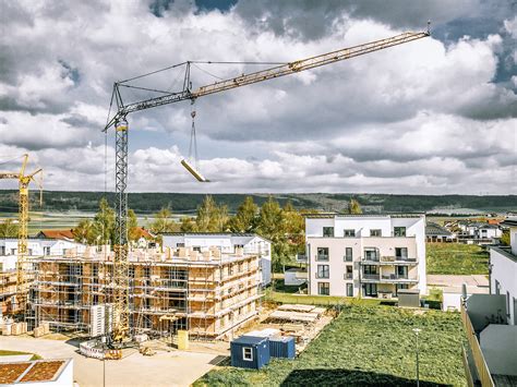 Thematic photo of a compact bottom-slewing tower crane on a narrow construction site in a city