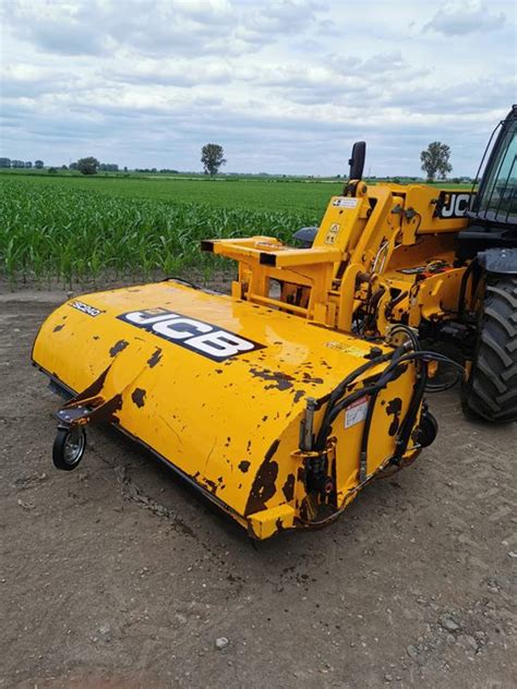 Zamiatarka JCB w akcji na placu budowy, usuwająca gruz i piasek