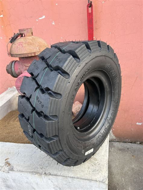 Thematic photo of a worn forklift tire next to a new one