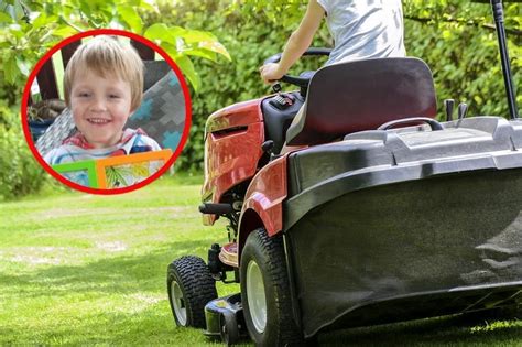 zdjęcie dziecka bawiącego się kosiarką zabawkową w ogrodzie