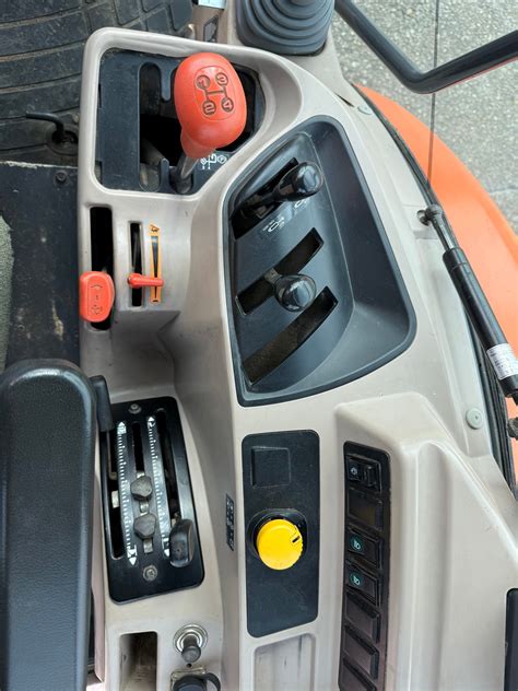 Wnętrze kabiny ciągnika Kubota M9960, pokazujące ergonomiczne rozmieszczenie dźwigni i kontrolerów