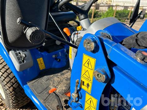 Minitraktor New Holland Boomer odśnieżający wąską drogę miejską