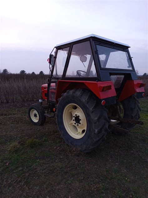 Zdjęcie przedstawiające ciągnik Zetor 4911 w pracy w polu z przyczepą