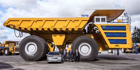 The BelAZ 75710 next to a smaller dump truck for scale