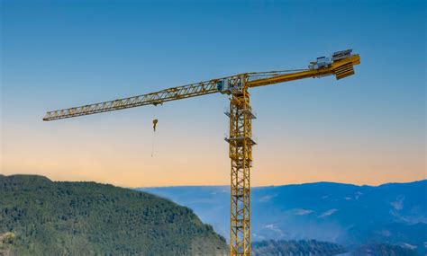 The Potain MCT 325 topless crane, 16-ton version, with a 75-meter jib length, in action on a construction site. Focus on its modular design and operational capabilities.