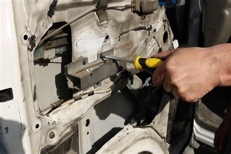 Zdjęcie przedstawiające proces smarowania prowadnic mechanizmu szyby minikoparki