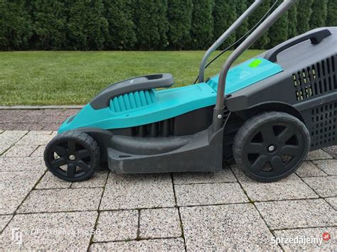 Zdjęcie kosiarki elektrycznej Gardena PowerMax 1100/32 w akcji, z widocznym koszem i uchwytem