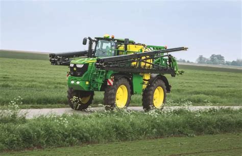 Zdjęcie przedstawiające nowoczesny opryskiwacz ciągany John Deere R962i pracujący na polu