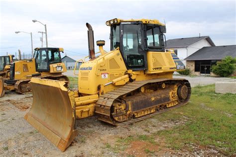 Widok wnętrza kabiny spychacza Komatsu D61, z zaznaczeniem ergonomii miejsca pracy operatora