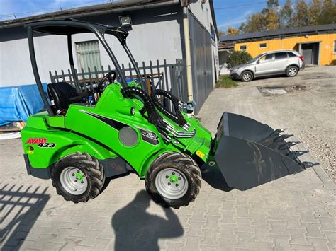 Ładowarka Avant z osprzętem w terenie miejskim