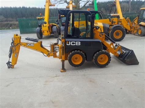 Schemat przedstawiający wszechstronność JCB 1CX: połączenie funkcji minikoparki i ładowarki burtowej w jednej bryle