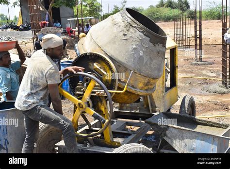 Thematic photo of a person operating a concrete mixer on a construction site
