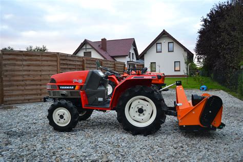 Tematyczne zdjęcie mini traktorka z kosiarką bijakową z koszem podczas pracy
