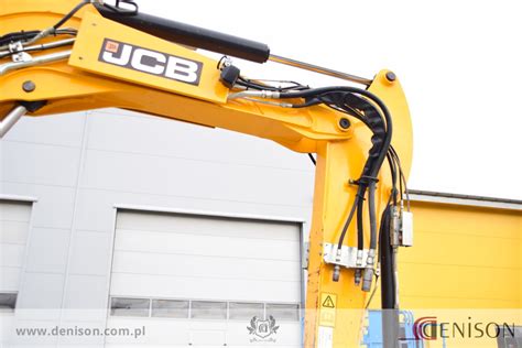Zestawienie różnych typów szybkozłączy zamontowanych na ramieniu koparki JCB