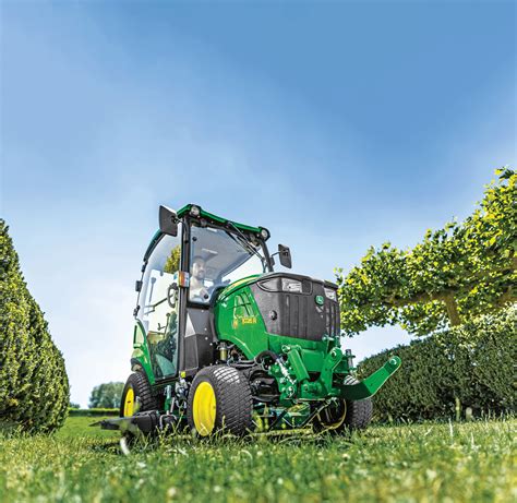 Elektryczny ciągnik kompaktowy John Deere z podłączonym opryskiwaczem