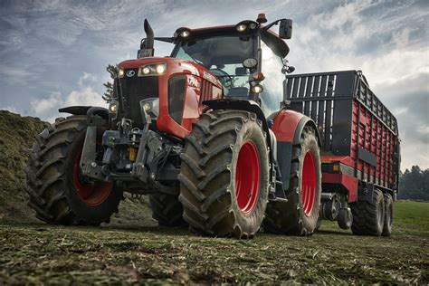 zdjęcie przedstawiające nowoczesny ciągnik rolniczy z dobrze widocznymi światłami i maszynami towarzyszącymi