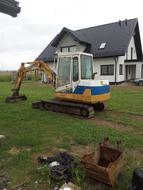 technik serwisujący koparkę Komatsu na budowie