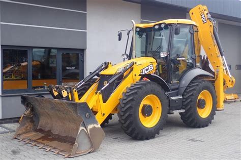 Koparko-ładowarka JCB 4CX podczas pracy na budowie