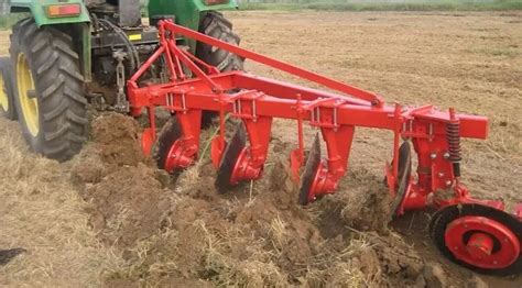Thematic photo of a 1-furrow plough attached to a mini tractor working in a field