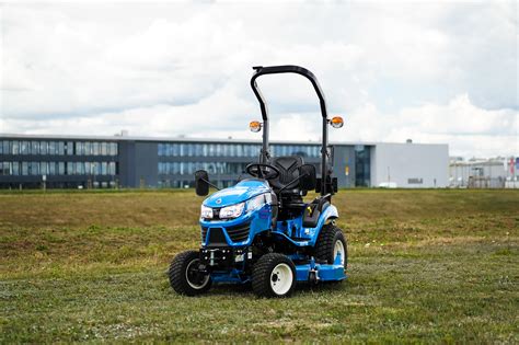 mini traktor Iseki z kosiarką rotacyjną na tle zielonego ogrodu