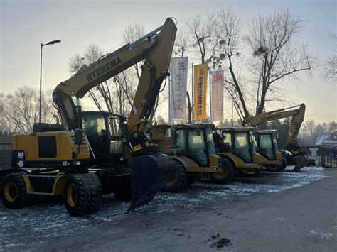 Logo firmy JCB na tle maszyn budowlanych
