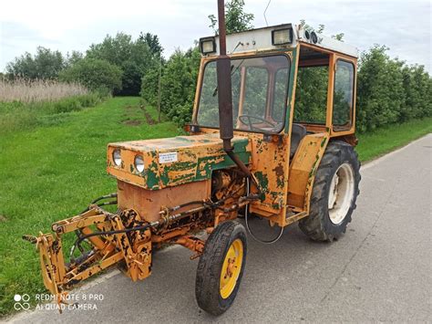 Zdjęcie przedstawiające klasyczny ciągnik ogrodniczy Gutbrod 70 w akcji na zadbanym trawniku