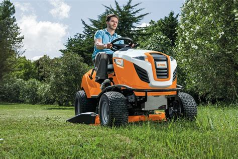 Zdjęcie przedstawiające traktorek ogrodowy Stihl w trakcie pracy w dużym ogrodzie