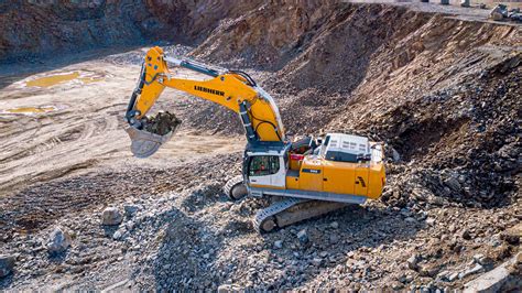 Różne modele koparek JCB, w tym mini koparki, koparki gąsienicowe i kołowe, ustawione obok siebie