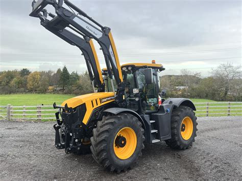 Thematic photo of a JCB Fastrac tractor working with a front loader on a paved surface