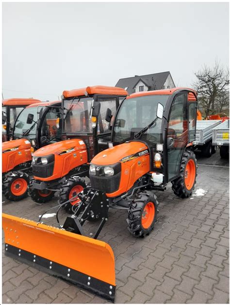 Traktor z pługiem odśnieżający drogę zimą