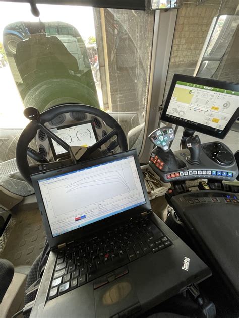 Zdjęcie mechanika podłączającego komputer diagnostyczny do ciągnika