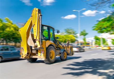 Zdjęcie przedstawiające różne modele koparko-ładowarek (JCB, Caterpillar, Ford) podczas pracy na placu budowy lub w ogrodzie