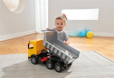 Dziecko bawiące się dużą wywrotką LENA Gigant Mercedes Arocs w piaskownicy