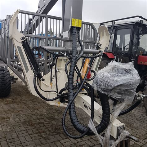 Koparko-ładowarka z widocznymi przewodami hydraulicznymi