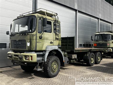 MAN 27.314 6x6 z platformą ładunkową i zamkami skrętnymi, przewożący kontener
