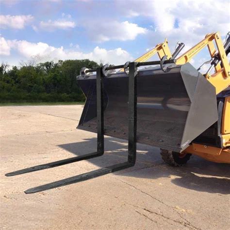 Thematic photo of a JCB backhoe loader with forks attached to the front bucket, lifting a pallet.