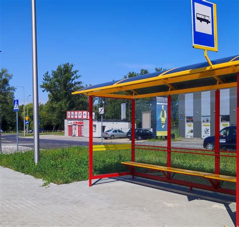 Zdjęcie przedstawiające przystanek autobusowy w Baligrodzie z widoczną grupą dzieci oraz autobusem szkolnym w tle, w scenerii późnej wiosny.