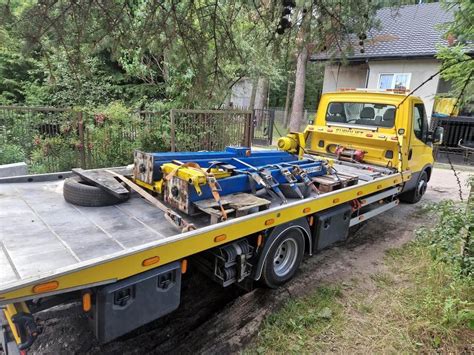 Ilustracja przedstawiająca transport maszyny budowlanej na lawecie